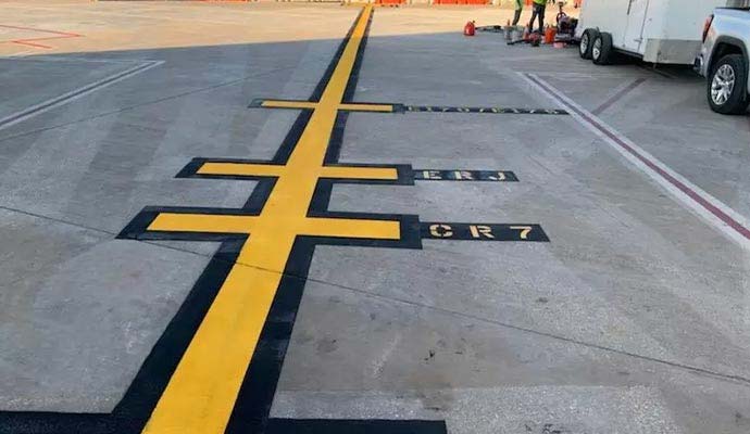 Airport apron tarmac with yellow and black painted aircraft lead-in lines