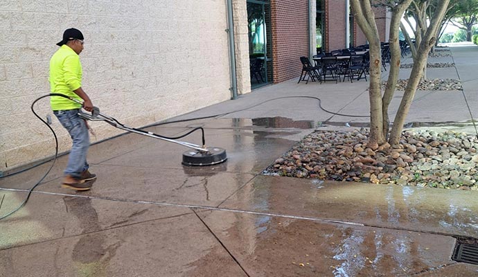 A person is cleaning commercial property walkway