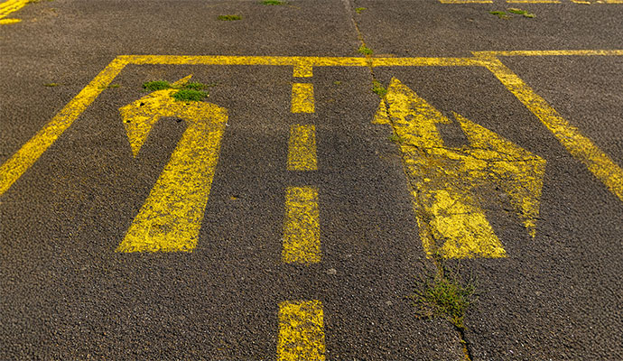 Faded yellow road markings on an asphalt surface