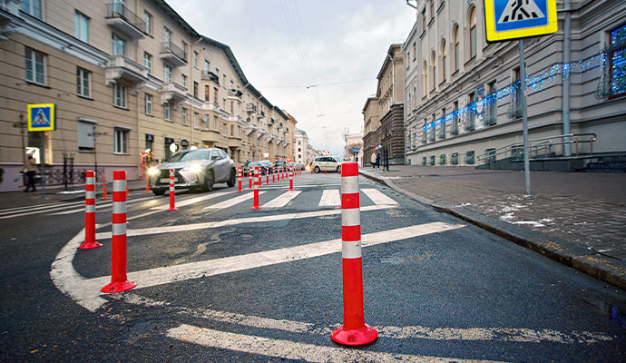 Flexible reflective traffic safety bollards installed along urban roadway and pedestrian crossing lane
