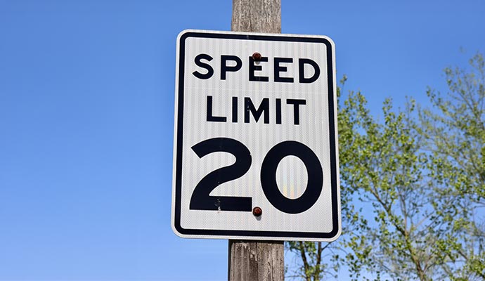 A 'SPEED LIMIT 20' regulatory traffic sign mounted on a post