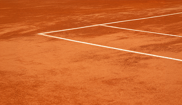 Close-up view of an outdoor tennis court surface and boundary lines