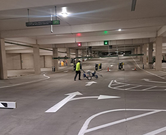 Indoor parking garage with freshly painted directional arrows lane markings and pavement striping layout
