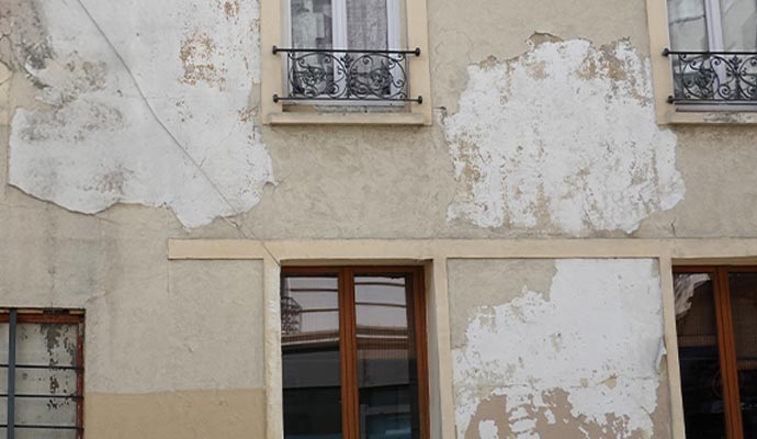 Painting a severely damaged building exterior