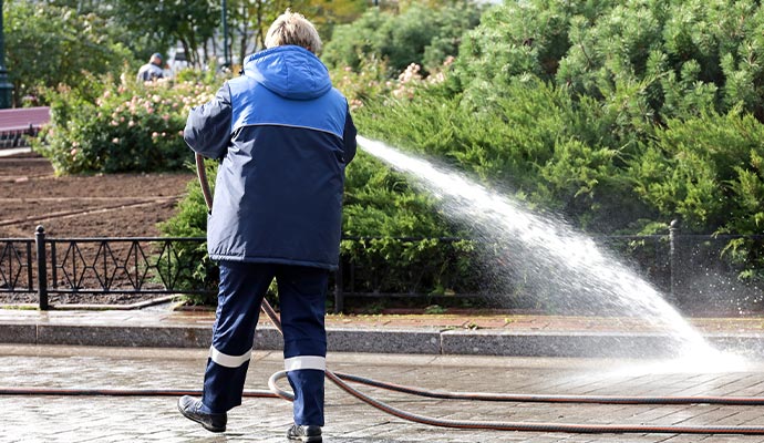 Professional worker cleaning paver sidewalk