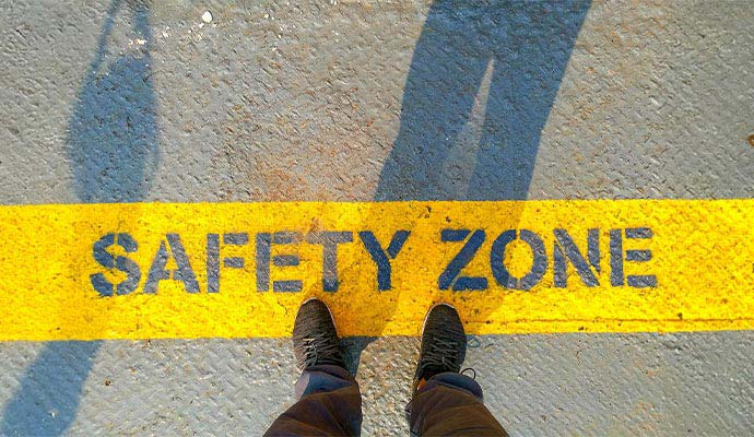 Painted yellow safety zone line with stenciled lettering on industrial floor